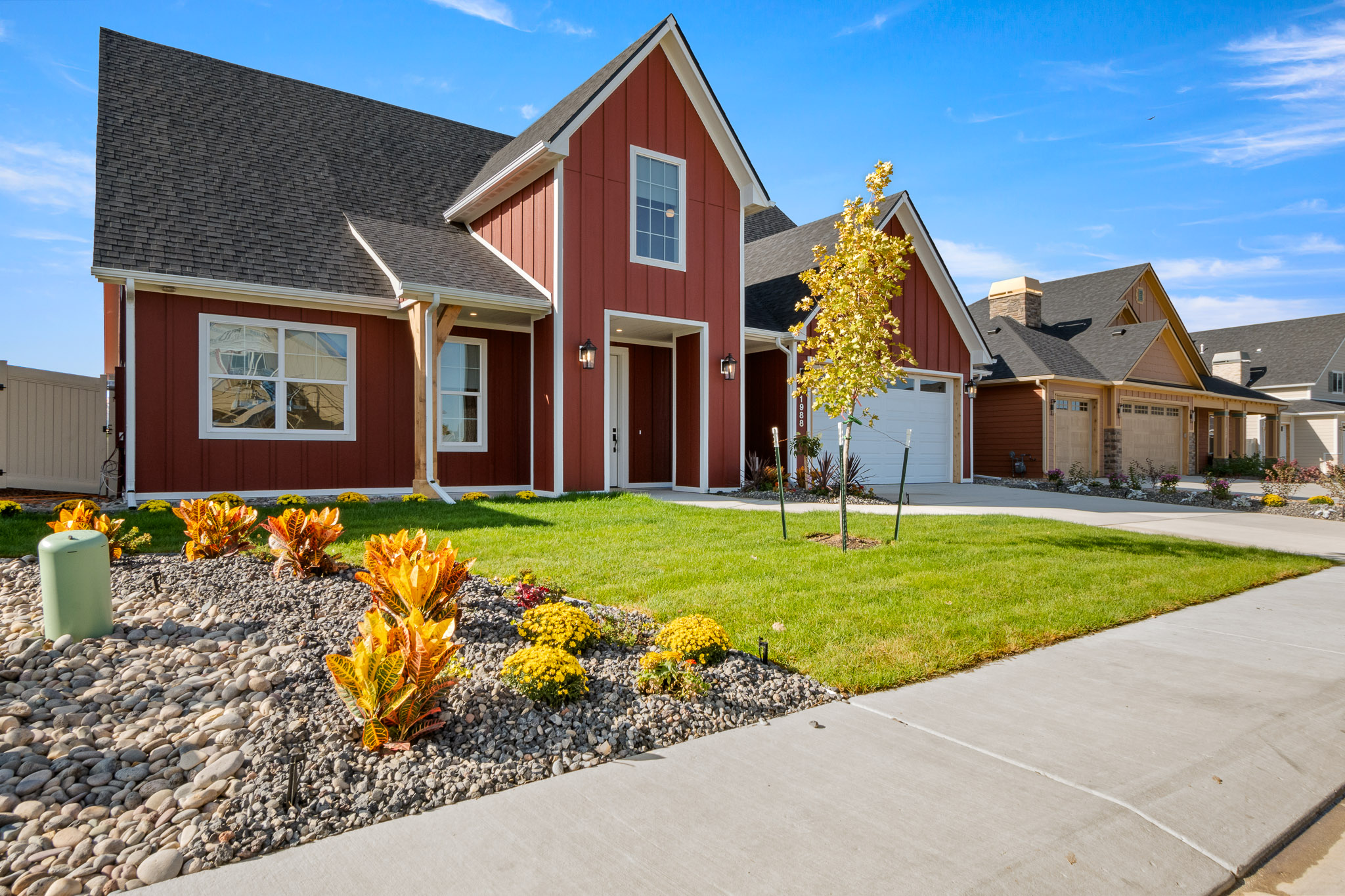 Front view of a Copper Creek’s Parade of Homes house: the Wellness Home features a sunny yard with green grass, spacious exterior, and inviting curb appeal